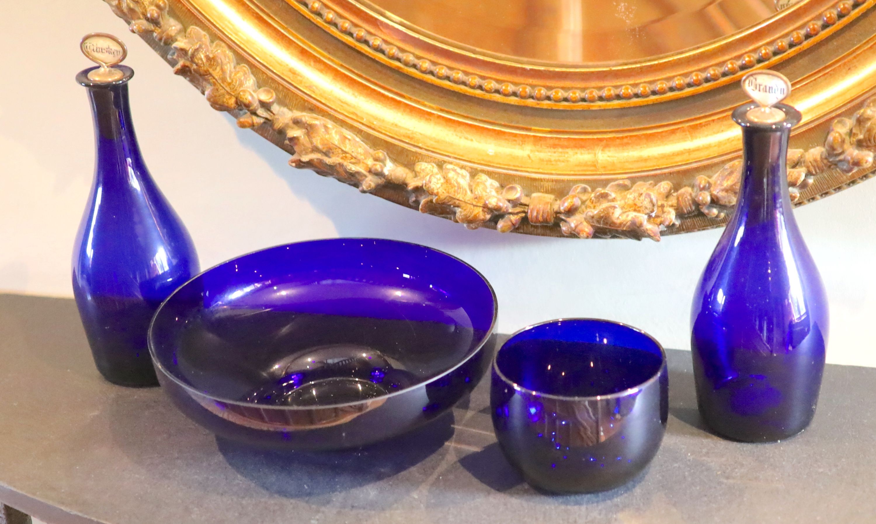 A pair of Bristol blue glass decanters with mother of pearl stoppers, height 28cm, a bowl, diameter 25cm and a finger bowl, diameter 12cm